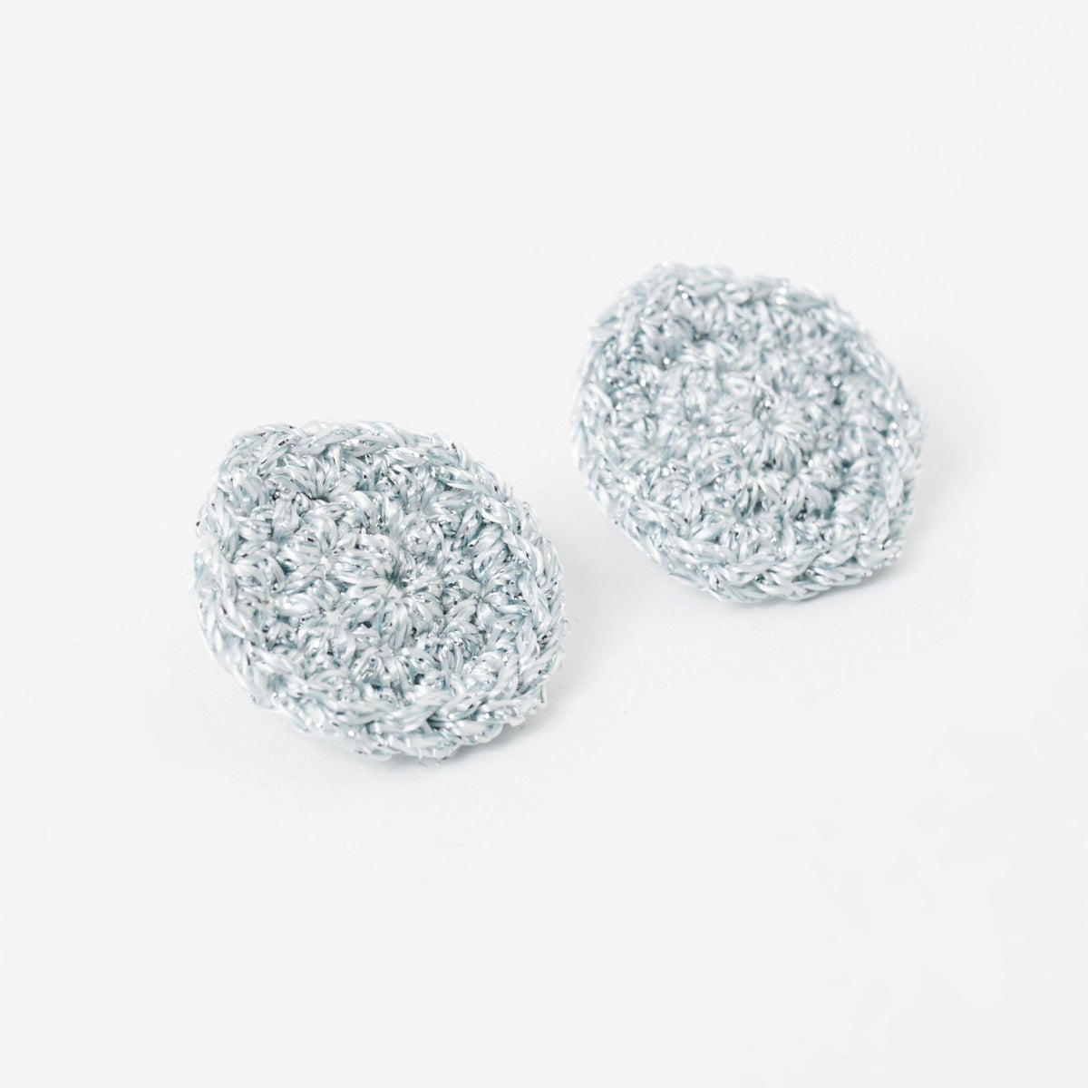 The Vela crochet disc earrings in pebble grey with silver shimmer, flat lay, second view - Lodorfo