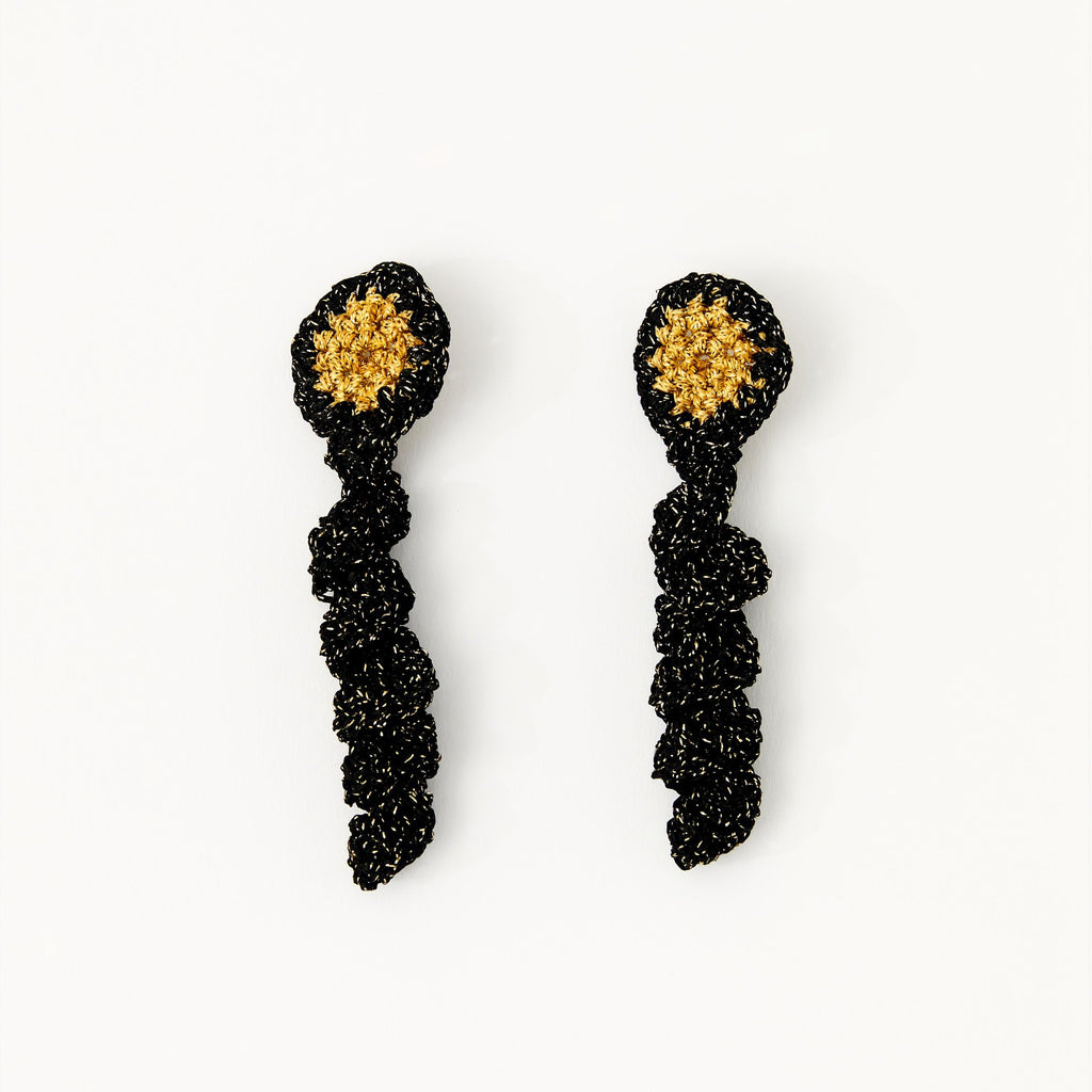 The Noire crochet drop earrings with a gold centre and black gold-sparkle spiral coil, flat lay - Lodorfo