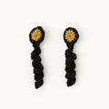 The Noire crochet drop earrings with a gold centre and black gold-sparkle spiral coil, flat lay - Lodorfo