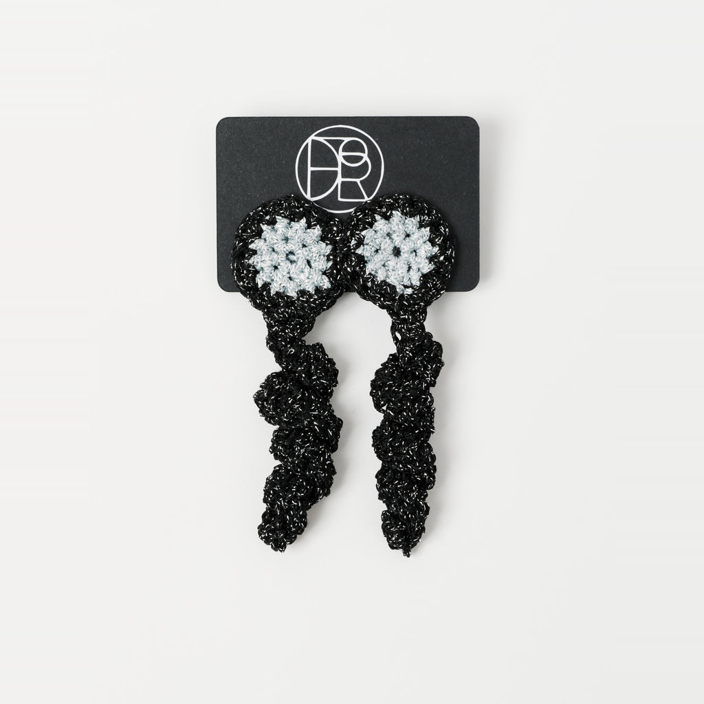 The Noire crochet drop earrings with a silver-grey centre, on a Lodorfo presentation card - Lodorfo