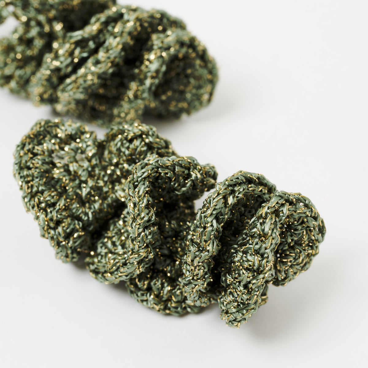 The Elara spiral drop earrings in Forest Green with gold shimmer, close up - Lodorfo