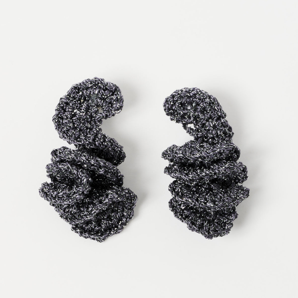 The Elara spiral drop earrings in Graphite Grey with silver shimmer, flat lay - Lodorfo