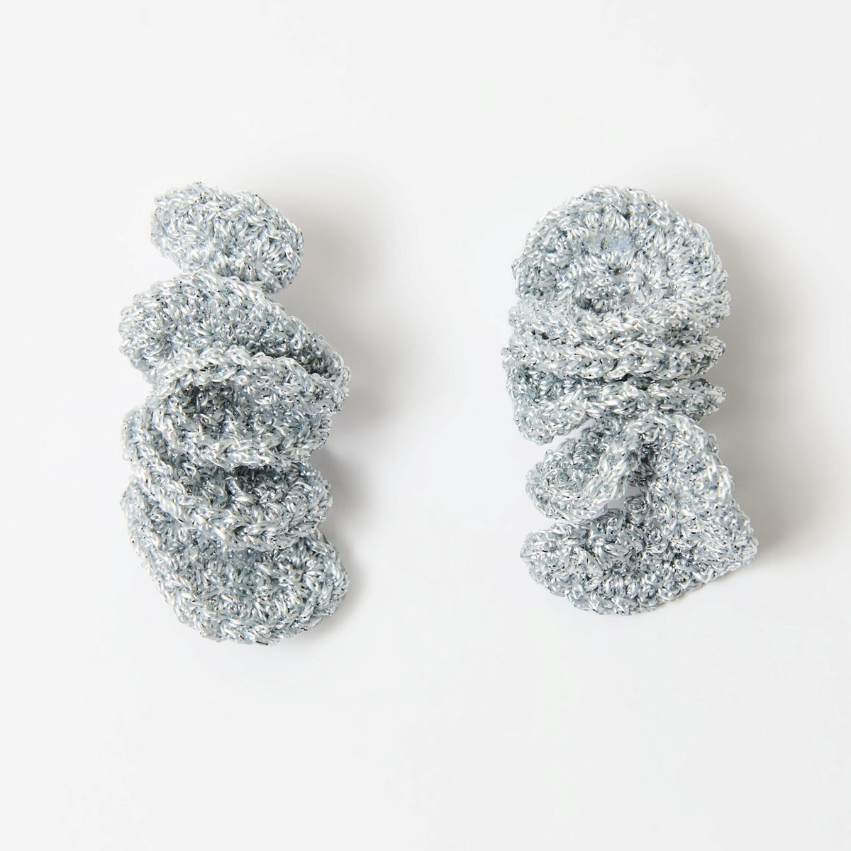 The Elara spiral drop earrings in Silver Grey with silver shimmer, flat lay - Lodorfo