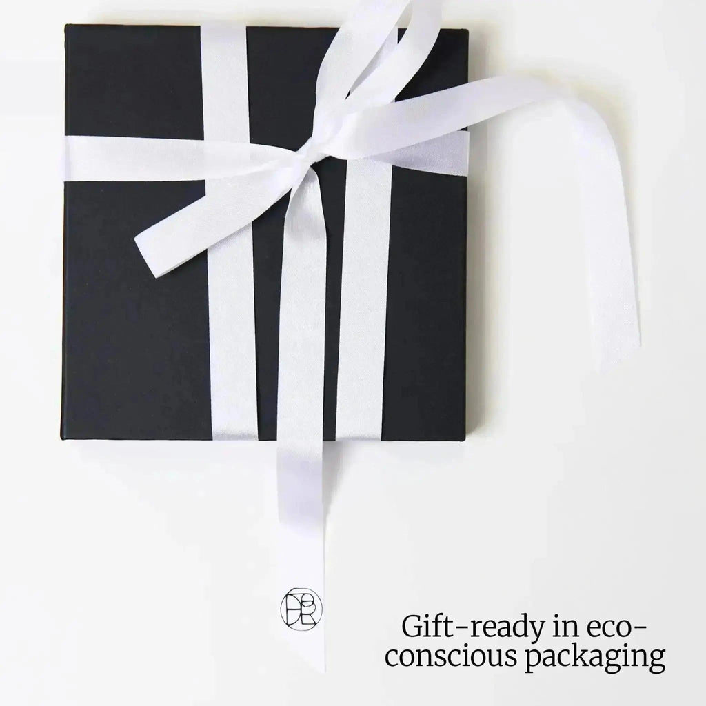 Black gift box with white ribbon on a white background, labelled 'Gift-ready in eco-conscious packaging'.