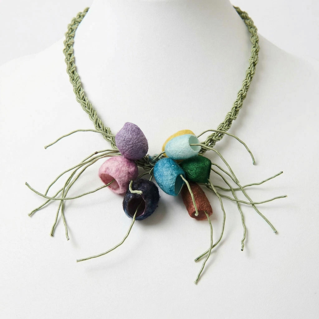 The Luma multicolour silk cocoon necklace on a sage green plaited cord, on a white ghost mannequin - Lodorfo