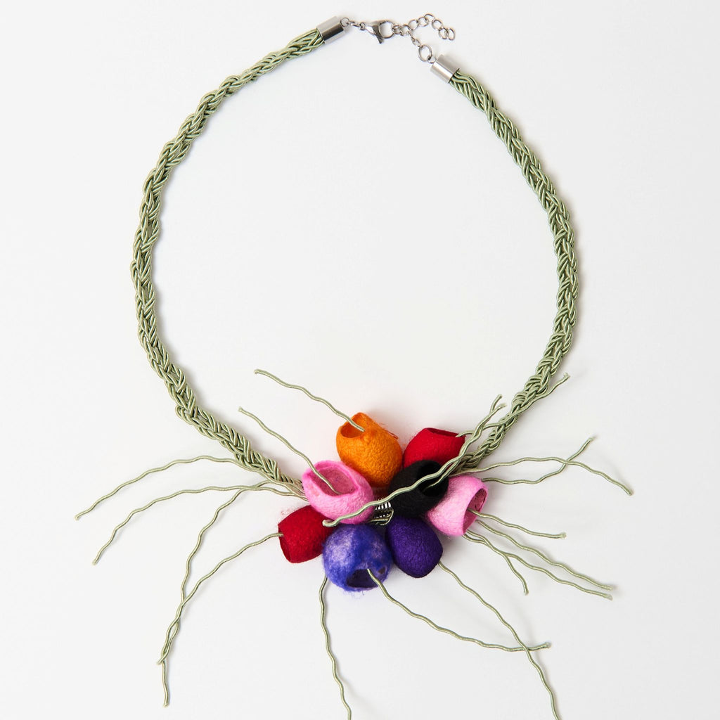 The Luma silk cocoon necklace laid flat, red, orange, pink and purple cocoons on a sage green plaited cord - Lodorfo