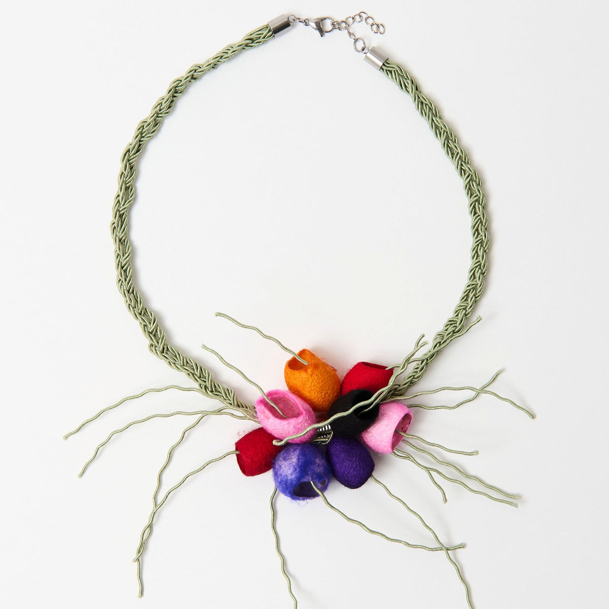 The Luma silk cocoon necklace laid flat, red, orange, pink and purple cocoons on a sage green plaited cord - Lodorfo