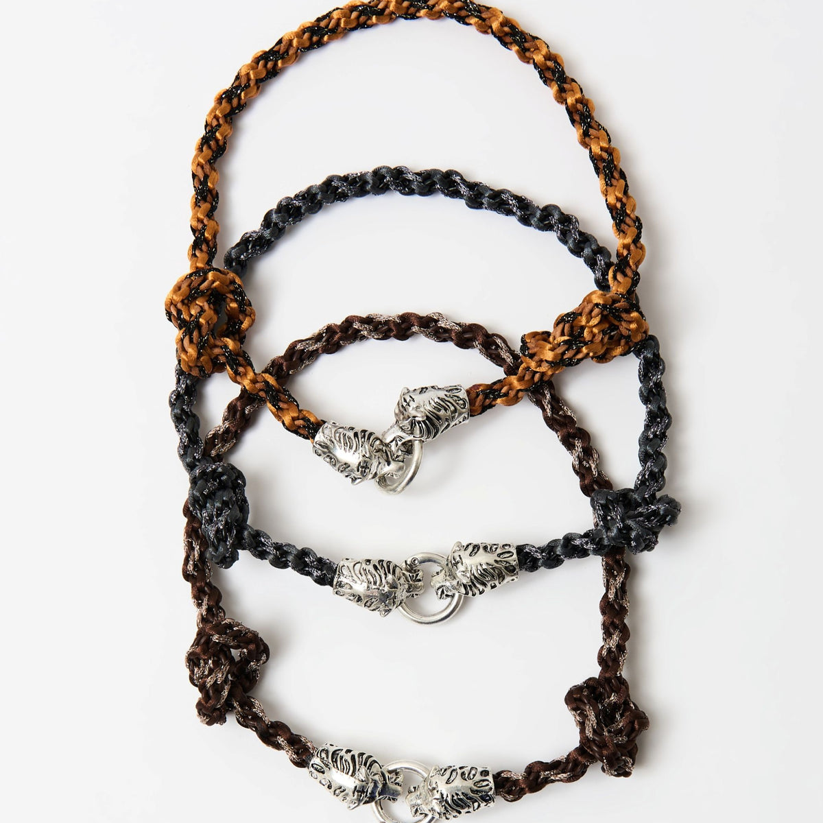 The three Kaelis wave-braided necklaces in burnt orange, midnight black and chestnut brown, stacked, with silver tiger head clasps - Lodorfo