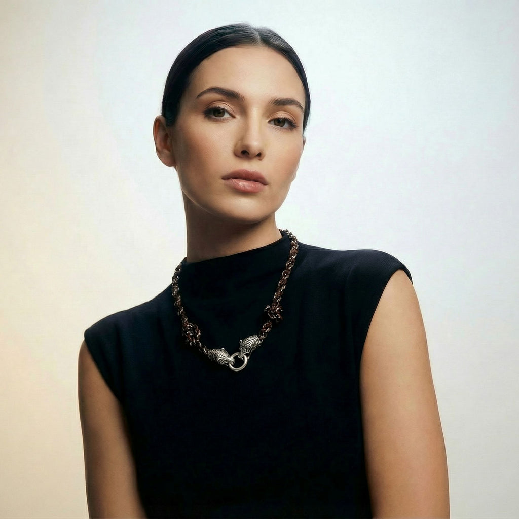Woman in a black sleeveless top wearing the Kaelis midnight black wave-braided necklace with silver tiger head clasp - Lodorfo