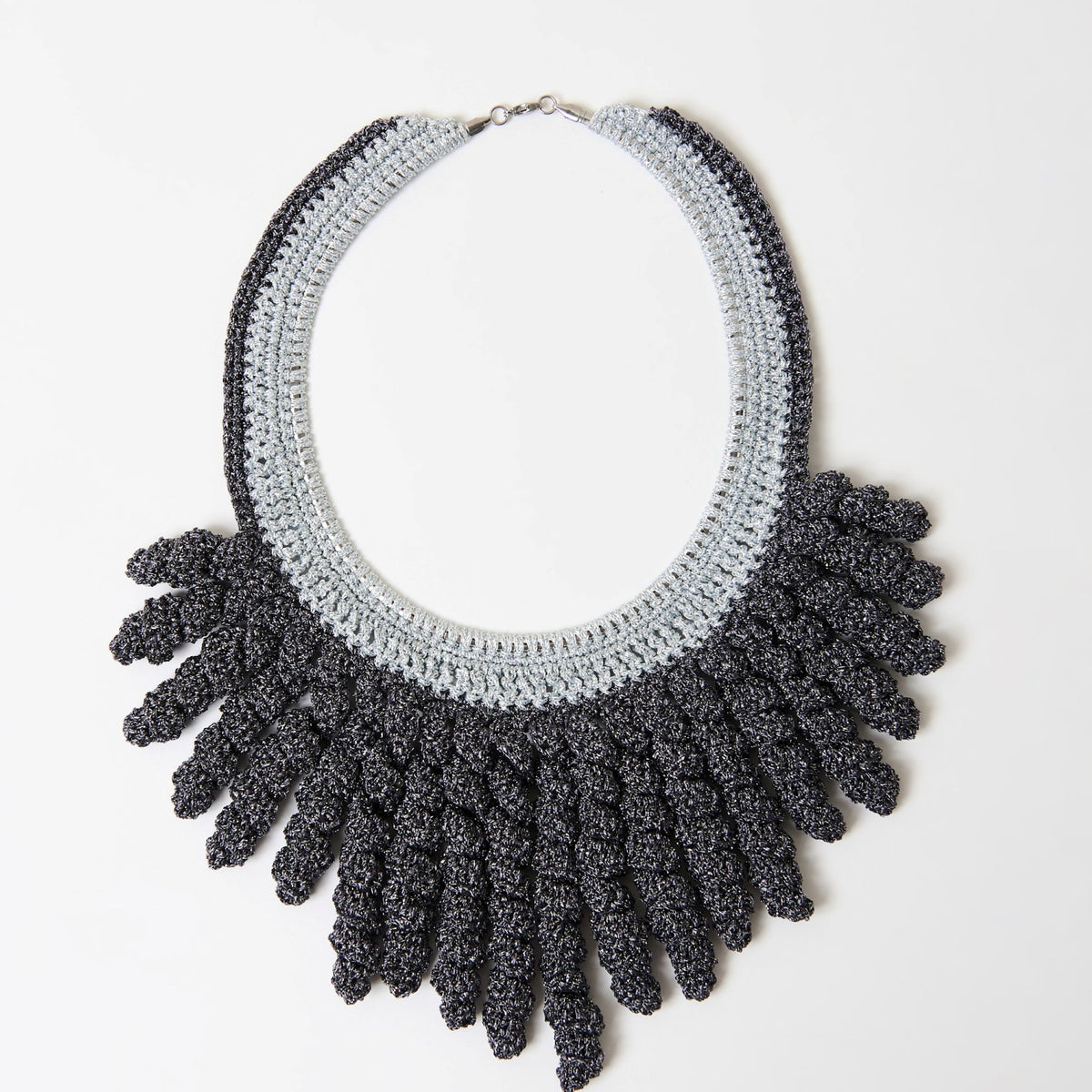 The Vetra graphite grey and silver mist crochet collar necklace with spiral fringe, laid flat - Lodorfo