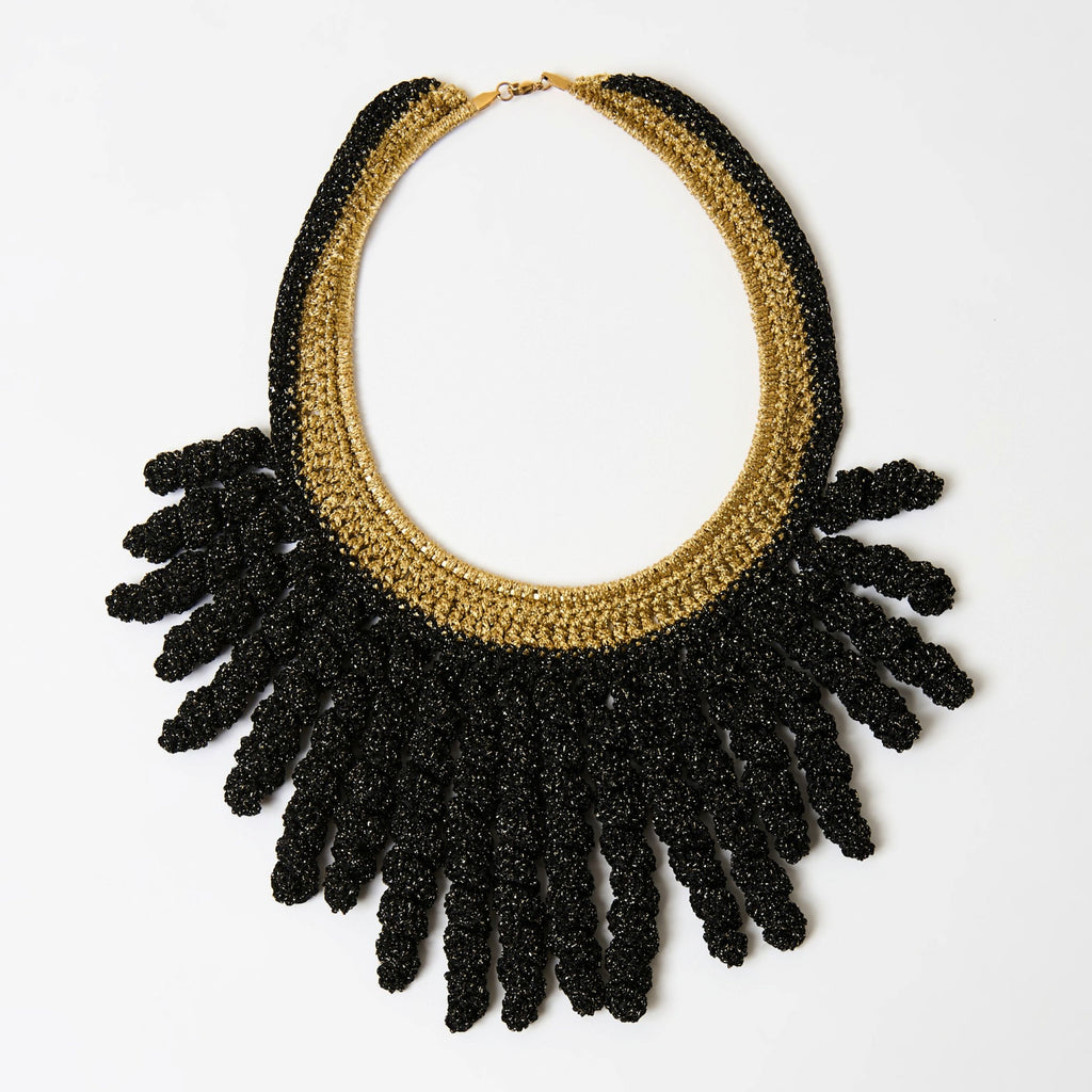 The Vetra midnight black and antique gold crochet collar necklace with spiral fringe, laid flat - Lodorfo