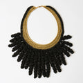 The Vetra midnight black and antique gold crochet collar necklace with spiral fringe, laid flat - Lodorfo