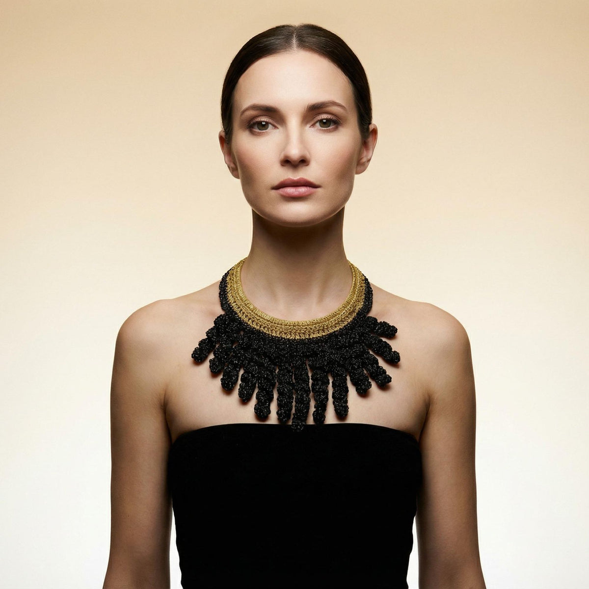 Woman with her hair back wearing the Vetra midnight black and antique gold crochet collar necklace - Lodorfo