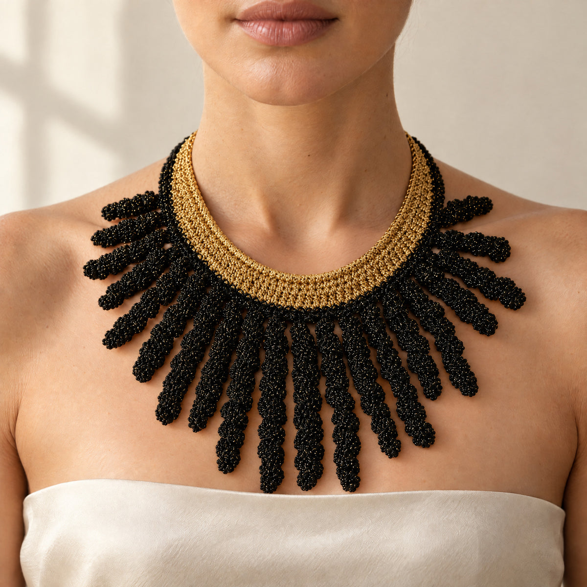 Woman wearing the Vetra midnight black and antique gold crochet collar necklace with spiral fringe, handmade UK - Lodorfo