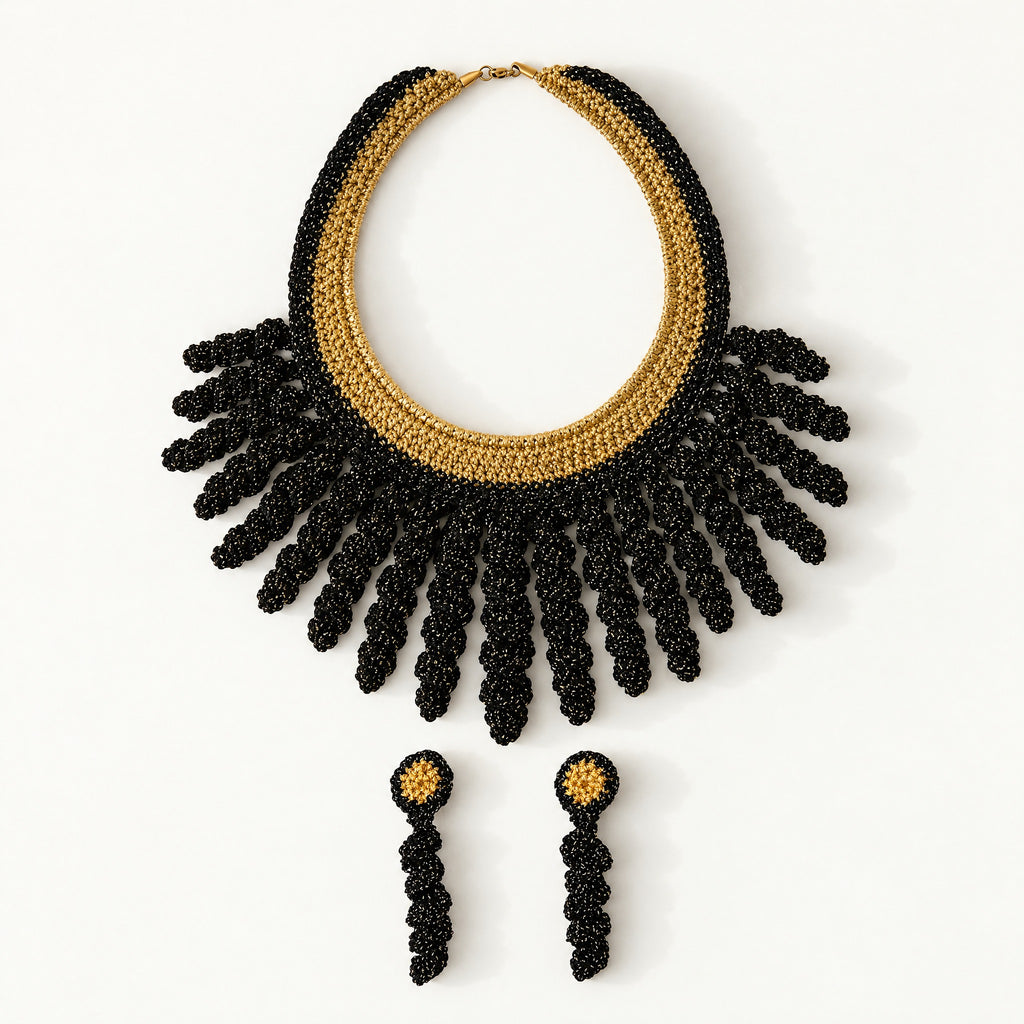 The Vetra Edit set: Vetra black and antique gold crochet collar necklace with Noire gold drop earrings, laid flat - Lodorfo