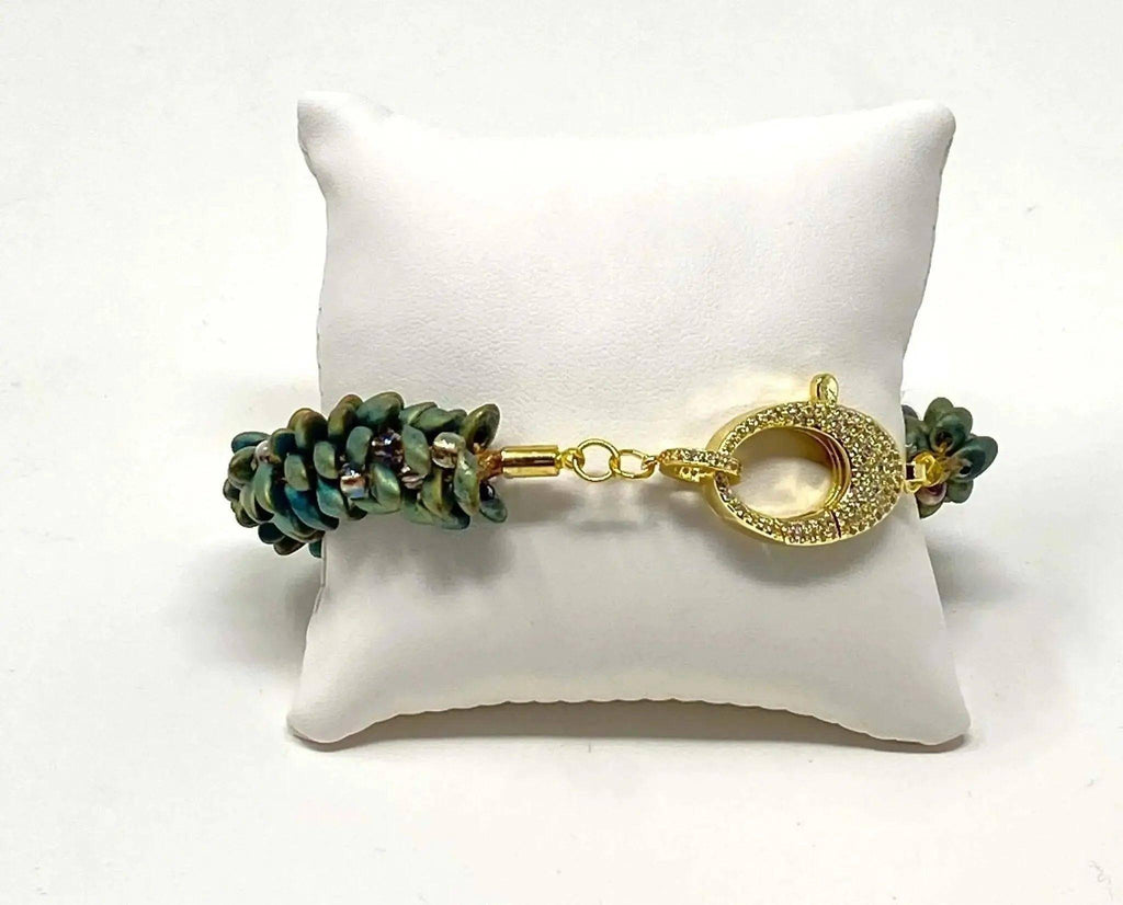 The Elio Beaded Bracelet shown on a display cushion.
