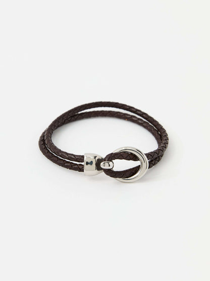 Brown braided leather bracelet with a sleek silver loop and knot clasp, showcasing a modern and minimalist style.