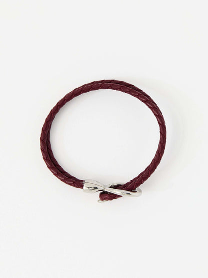 Red braided leather bracelet with a sleek silver loop and knot clasp, showcasing a modern and minimalist style.
