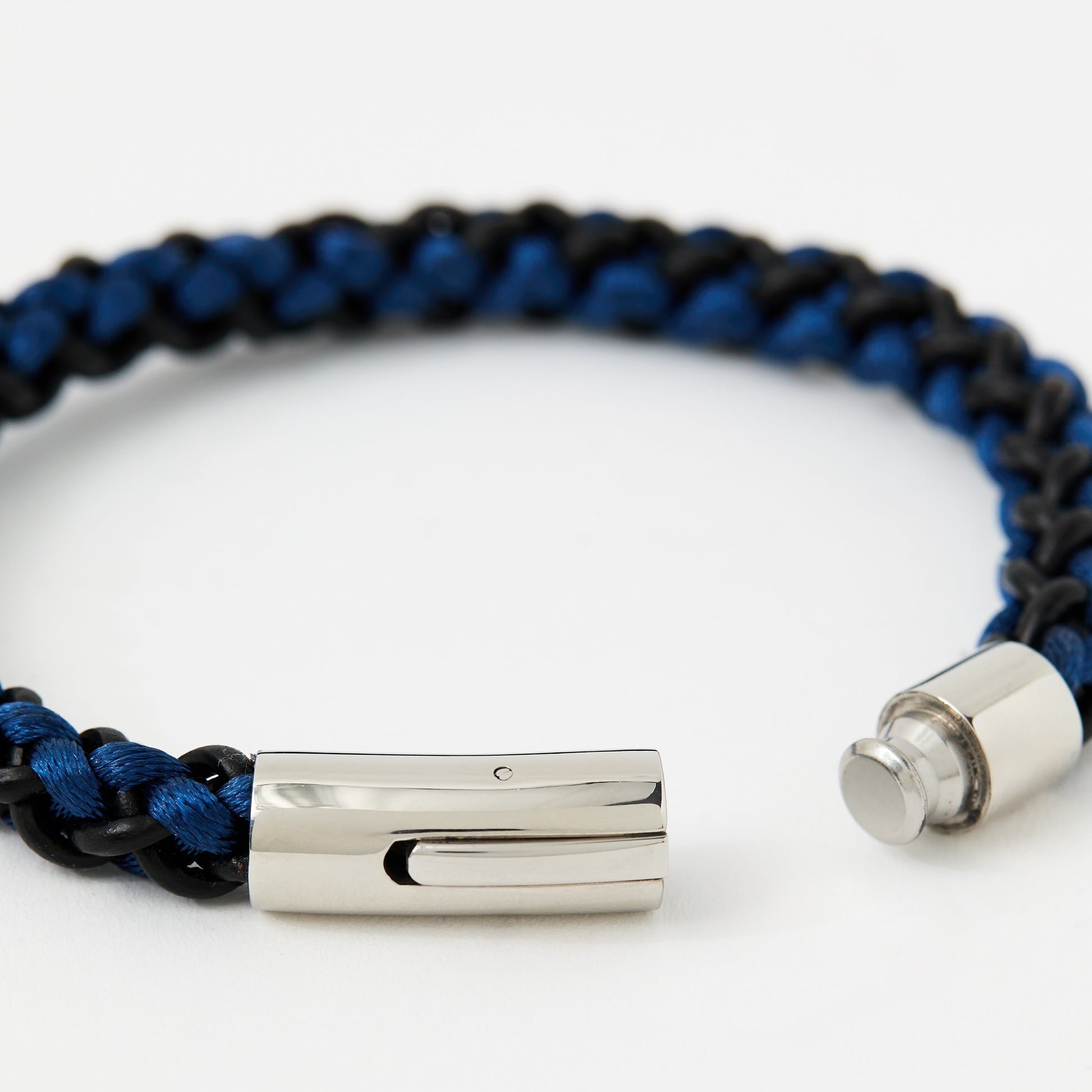 Blue and black braided bracelet with silver clasp on a white background