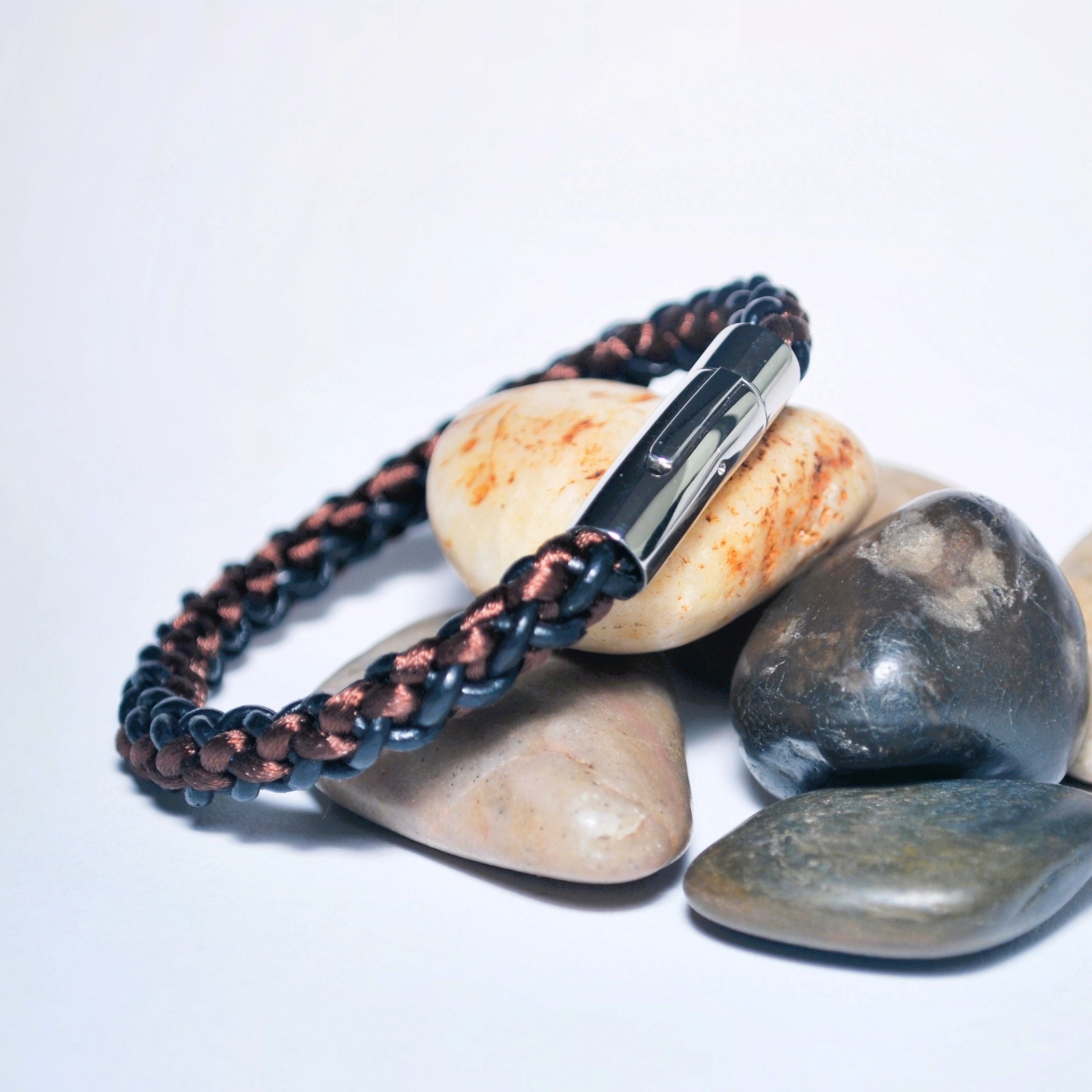 Bracelet with metal clasp on stones against a white background