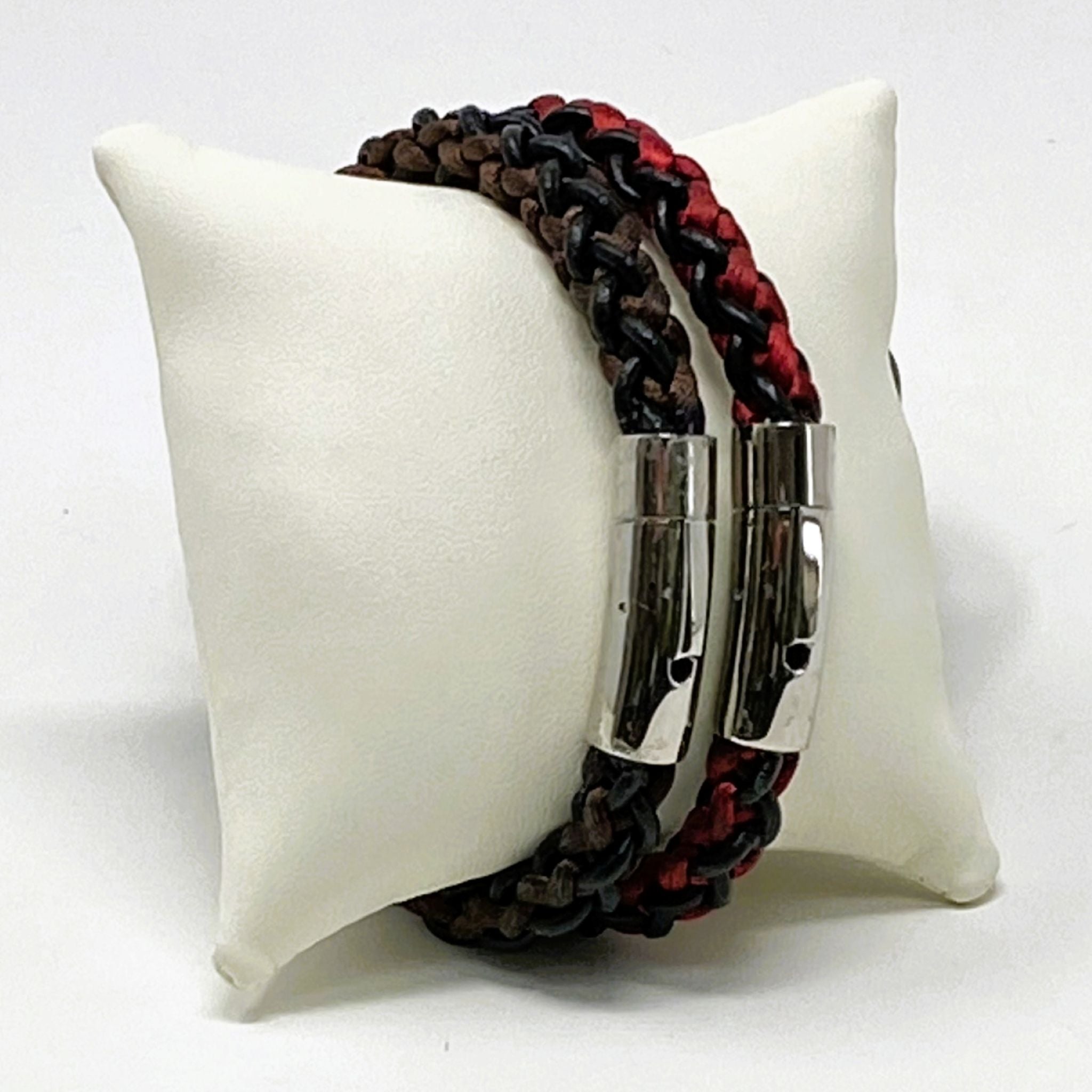Bracelet with black and red braided design on a white cushion