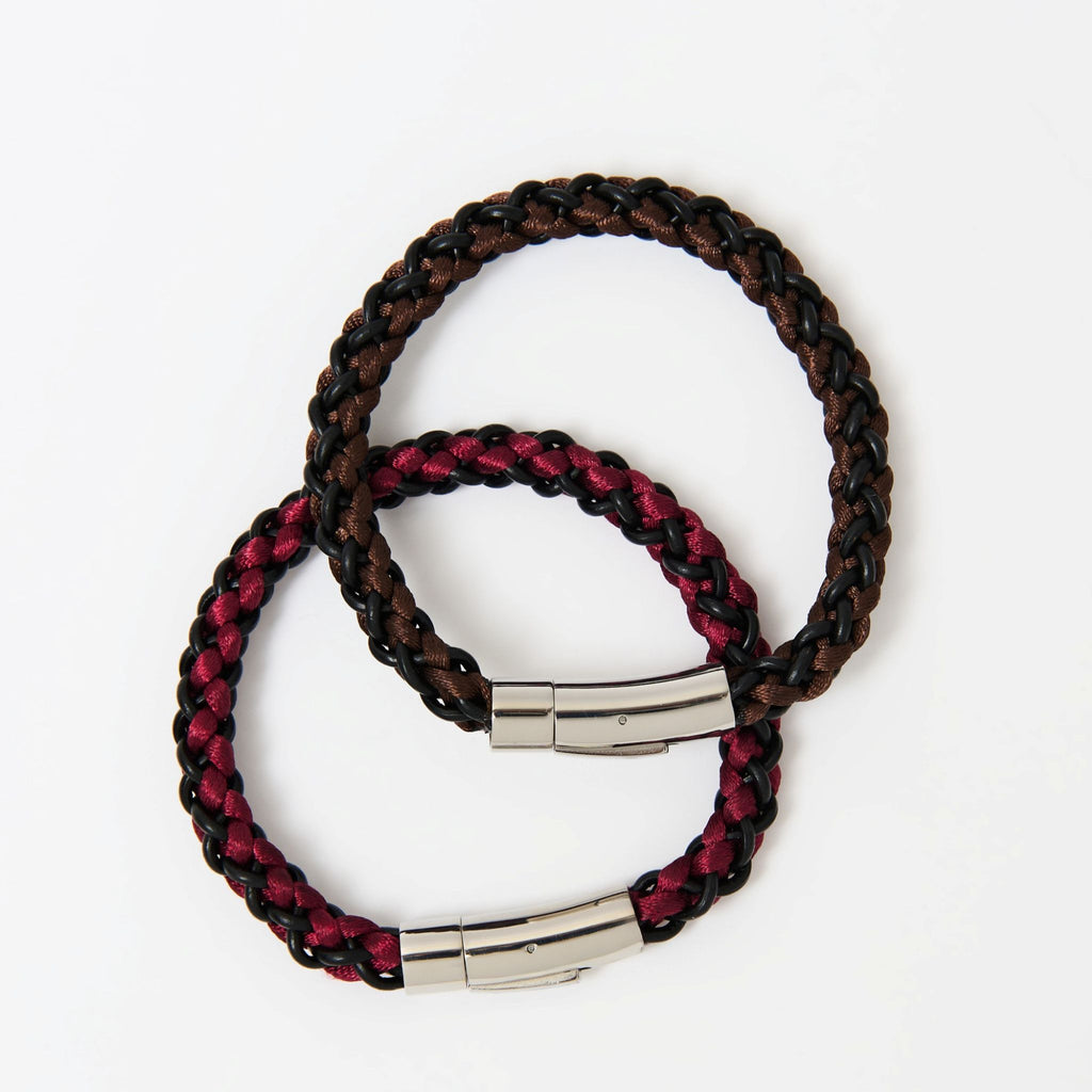 Two braided bracelets with metal clasps on a white background