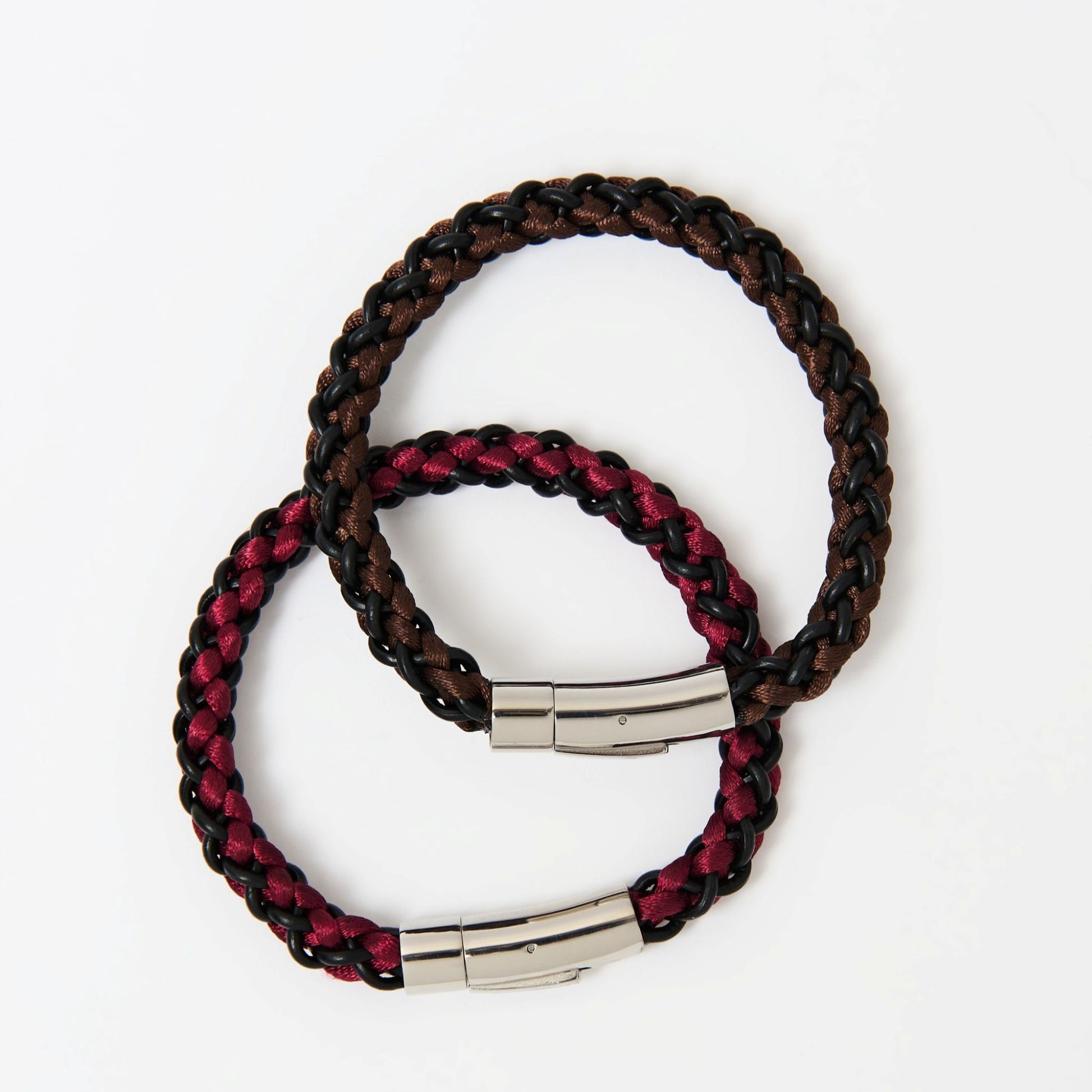 Two braided bracelets with metal clasps on a white background