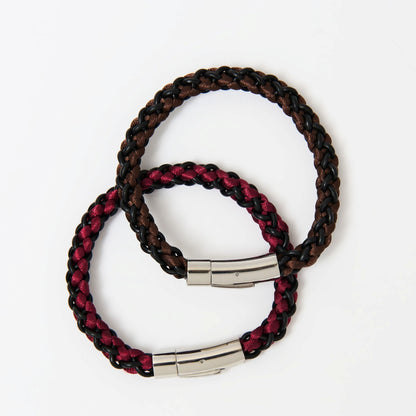 Two braided bracelets with metal clasps on a white background