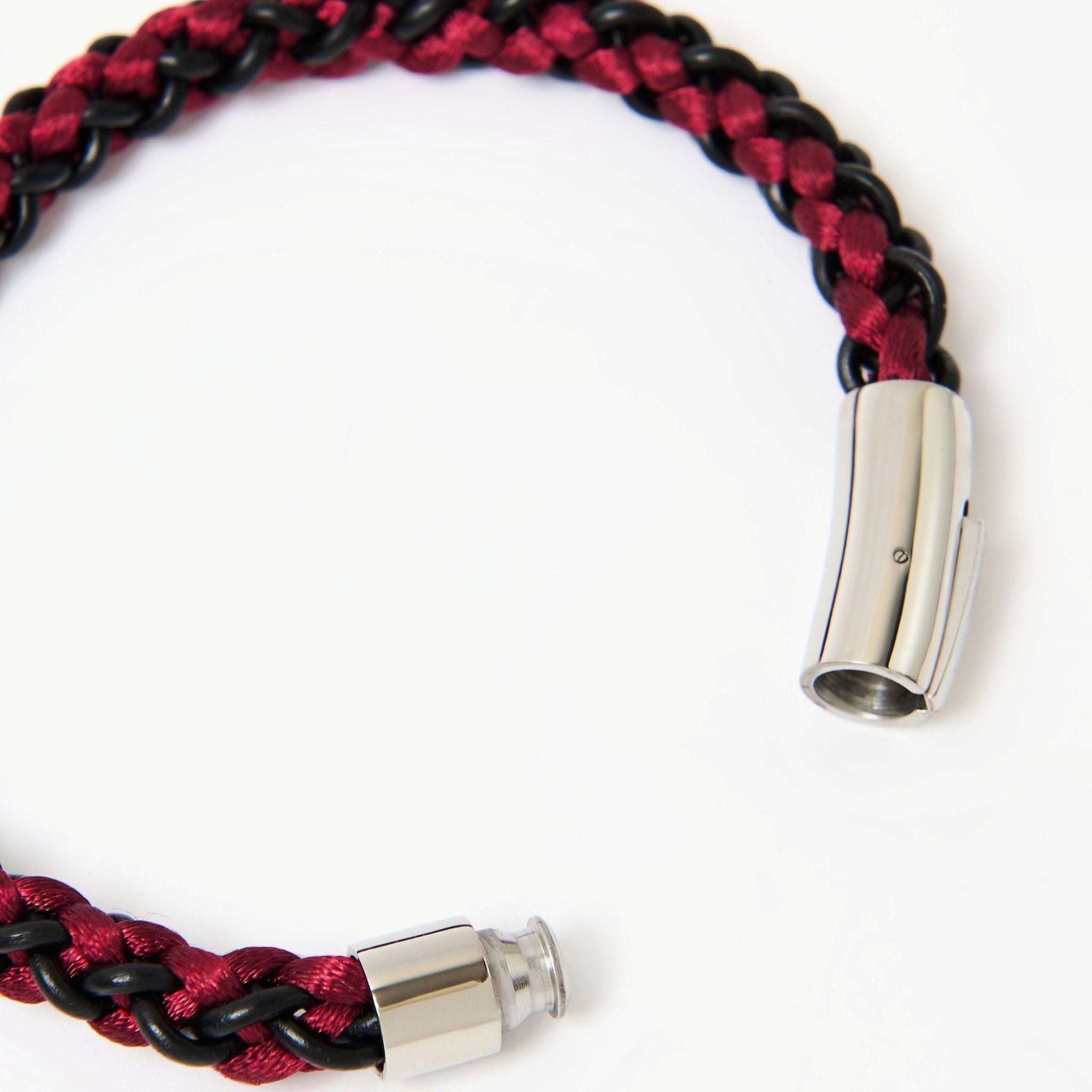 Bracelet with red and black braided cord and silver clasp on a white background