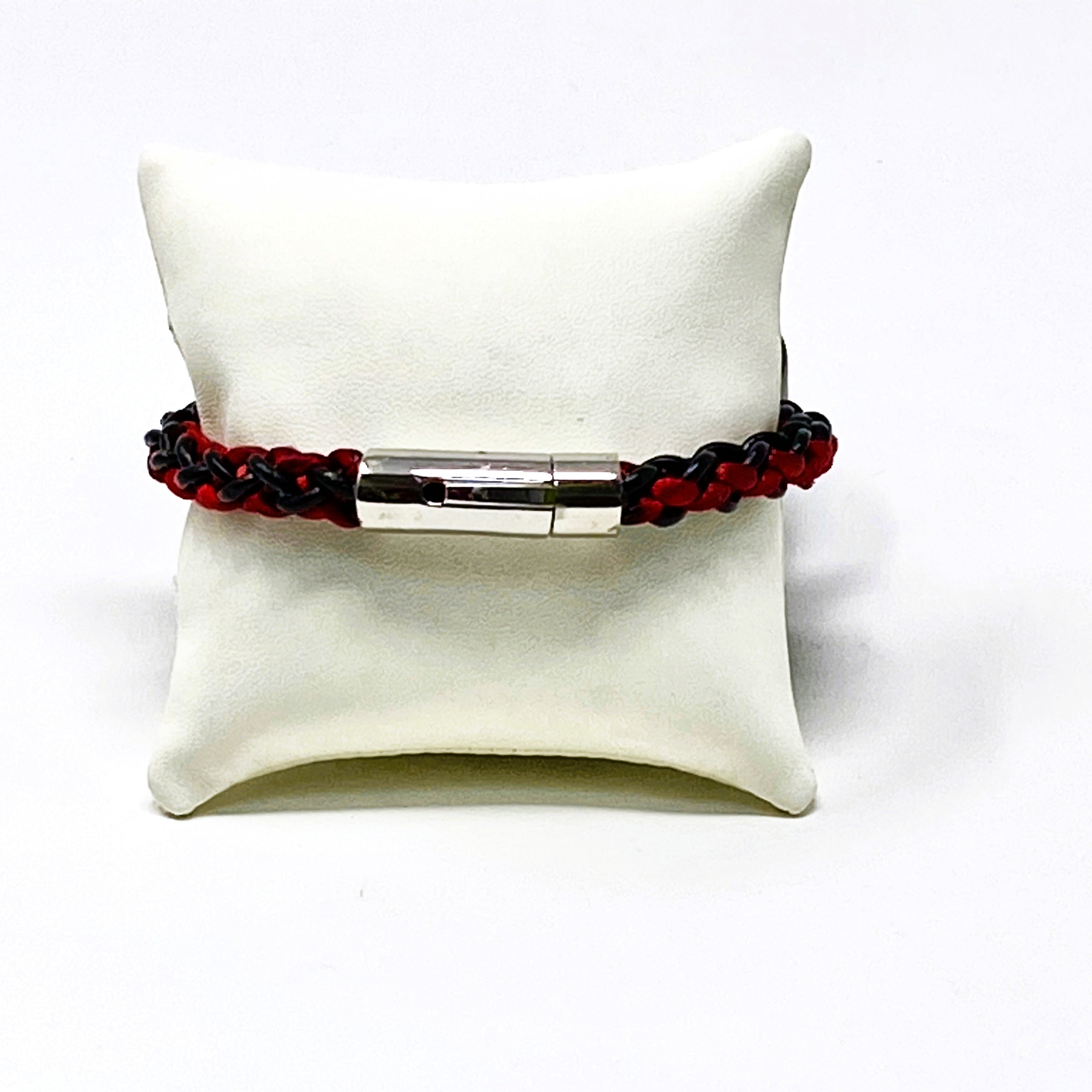 Bracelet with red and black beads on a white cushion