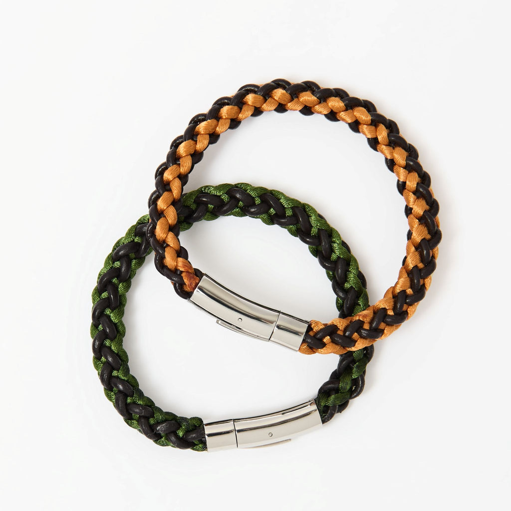 Pair of artisan men's braided leather bracelets in forest green and burnt orange with sleek stainless steel clasps — eye-catching accessories for everyday wear.