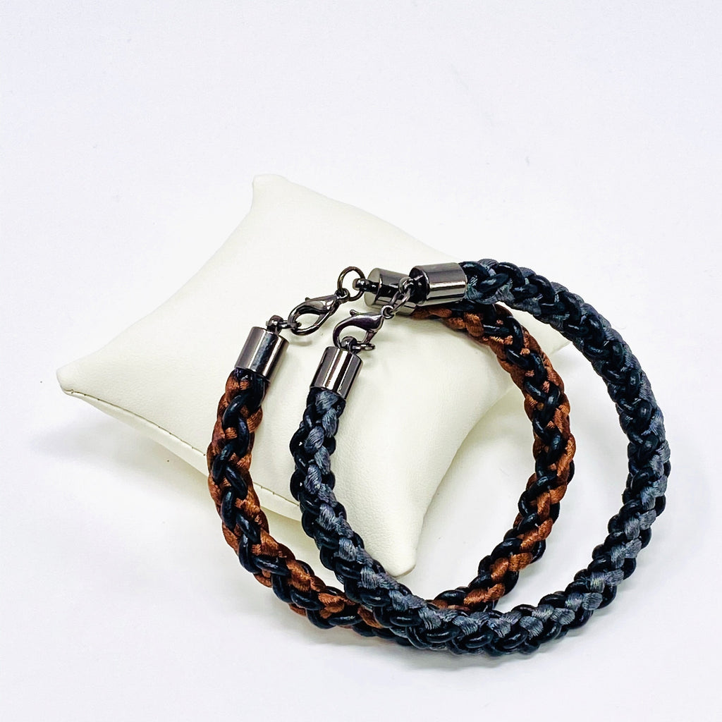 Two men’s braided leather bracelets in brown and grey with silver lobster clasps — handcrafted gifts for him, perfect for couples or friends.