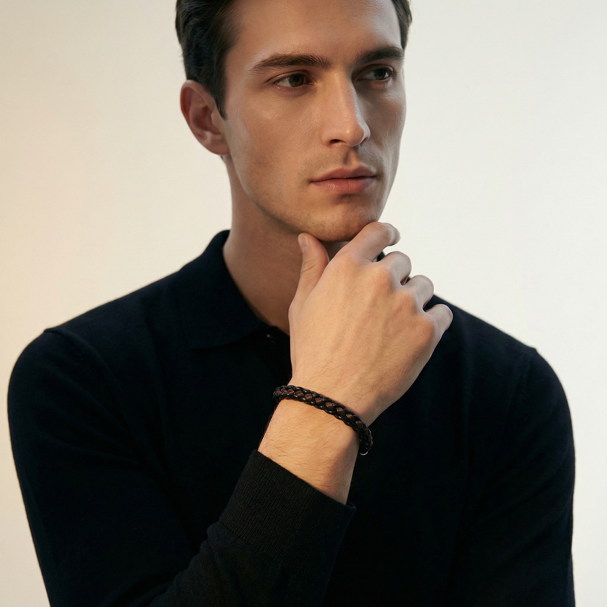 Black braided leather bracelet on male model's wrist, stylish men's jewellery accessory