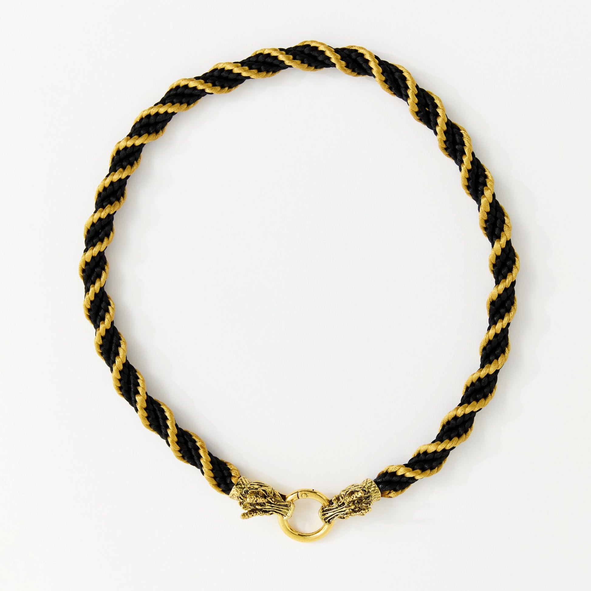 Handmade black and gold spiral satin cord necklace with dragon head clasp, arranged in a full circle on a white background.