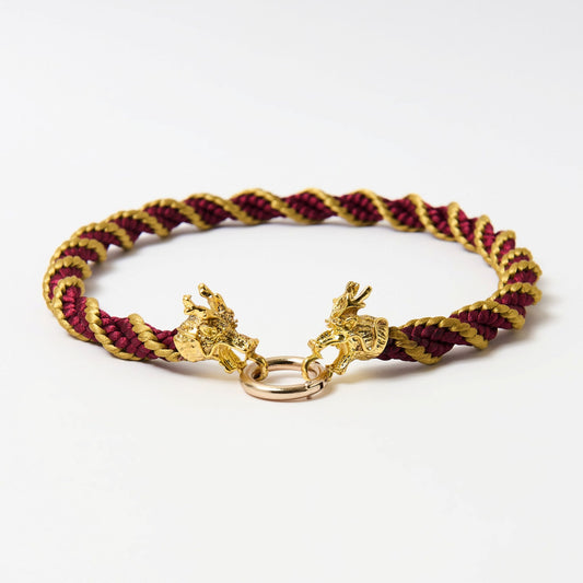 Handmade spiral red and gold satin cord necklace with ornate dragon head clasp, arranged in a semi-circle on a white surface.